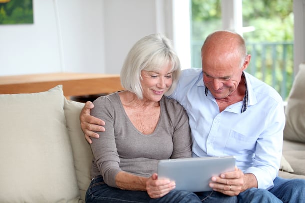 Senior couple using electronic tablet at home